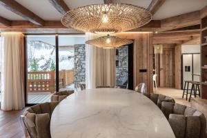 a dining room with a large marble table and chairs at Penthouse Best View - Les Chalets COVAREL in Val-d'Isère