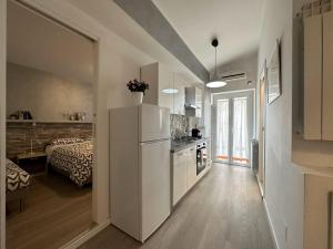 a kitchen with a white refrigerator and a bedroom at Santa Lucia in Caltanissetta
