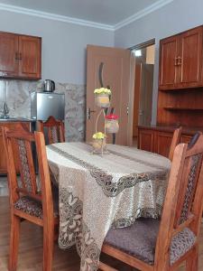 a kitchen with a table with chairs and a table cloth at GIMZI in Kutaisi