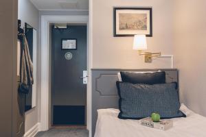a bedroom with a bed with a pillow and a lamp at Crystal Plaza Hotel in Stockholm