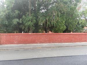 una valla de ladrillo rojo al lado de una calle en The Willows, Newark-On-Trent, en North Muskham