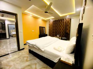 una camera con letto bianco e soffitto di Elite Living Hotels a Rawalpindi