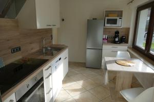 a kitchen with a sink and a table and a refrigerator at Ferienwohnung Hilberath in Wimbach +10 photos