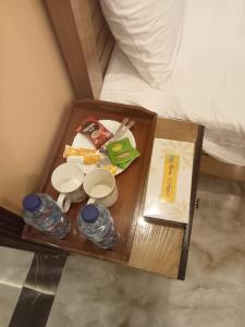 een dienblad met eten en drinken op het bed bij Elite Living Hotels in Rawalpindi