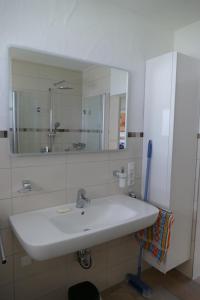 a bathroom with a white sink and a mirror at Ferienwohnung Hilberath in Wimbach