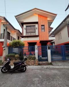 een motorfiets geparkeerd voor een huis bij Espina's Residence in Batangas City