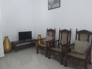 Habitación con sillas, TV y mesa. en Ariyana resort, en Athurugiriya