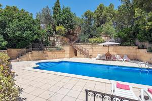 a swimming pool with two chairs and an umbrella at Holiday Villa Beauty Andratx in Capdellá