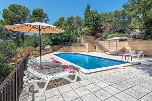 a swimming pool with lounge chairs and an umbrella at Holiday Villa Beauty Andratx in Capdellá