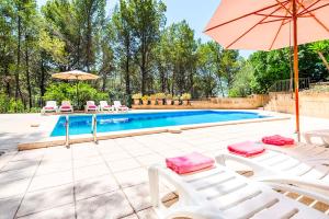 a swimming pool with two lawn chairs and an umbrella at Holiday Villa Beauty Andratx in Capdellá