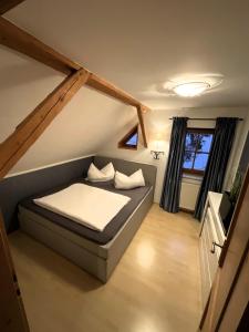 ein kleines Schlafzimmer mit einem Bett im Dachgeschoss in der Unterkunft Ferienwohnung Aigner in Schellgaden