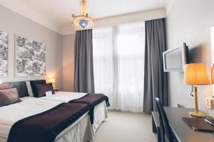 ein Hotelzimmer mit einem Bett, einem Schreibtisch und einem Fenster in der Unterkunft Crystal Plaza Hotel in Stockholm
