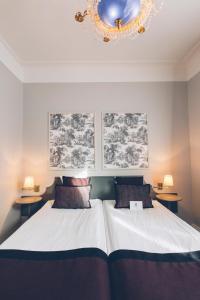 a bedroom with a large bed and a chandelier at Crystal Plaza Hotel in Stockholm