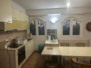 a kitchen with white appliances and a table and chairs at Vila Varadero in Skopje