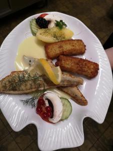 a white plate of food with eggs sausage and vegetables at Hotel Waldsee in Waldachtal