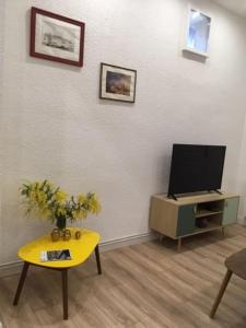 uma sala de estar com uma TV e uma mesa em Le chant des vagues em Sète