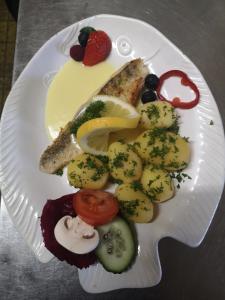 瓦爾達赫陶的住宿－Hotel Waldsee，一块食物,上面有鱼、蔬菜和水果