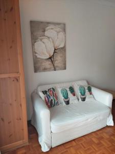 um sofá branco com quatro almofadas num quarto em Covelo no Porto
