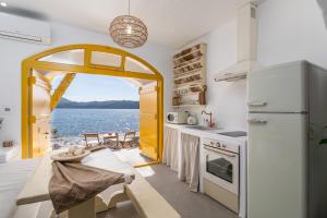 a kitchen with a view of the water at Salty Splash & Kyma Sirma Klima in Klima