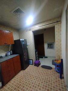 a kitchen with a black refrigerator in a room at Fully furnished room in Sharjah