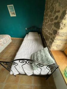 a small bed in a room with a stone wall at chambre Saint Malo in Saint-Méloir-des-Ondes