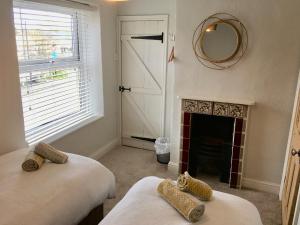 a bedroom with two beds and a fireplace at The Burrow in Wetherby