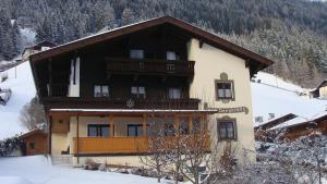 een gebouw met een balkon op een met sneeuw bedekte berg bij Haus Bergkranz in Neustift im Stubaital