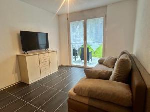 a living room with a couch and a flat screen tv at Gemütliche Wohnung mit Bergblick in Herbriggen