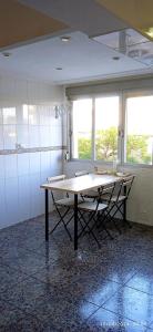 a table in a room with two chairs and two windows at Habitaciones y Suite. UPV, UV y Playa in Valencia