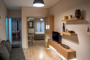 a living room with a couch and a flat screen tv at Perikleous 5 Diamerisma KONDOULIS HOUSE in Kalabaka