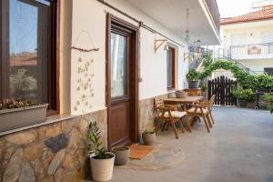 un patio con puerta de madera, mesa y sillas en Alexandras guesthouse, en Neos Panteleimonas
