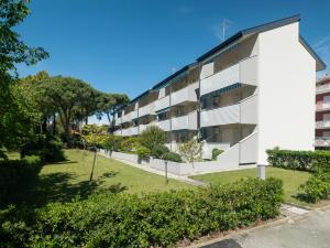 an apartment building with a park in front of it at Oasi di comfort 6 posti letto eleganza a Lignano in Lignano Sabbiadoro