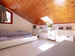 ein Schlafzimmer mit zwei Betten und einer Holzdecke in der Unterkunft Oasi di comfort 5 posti letto eleganza a Lignano in Lignano Sabbiadoro