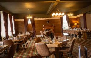 a restaurant with tables and chairs in a room at Balavil Hotel in Newtonmore