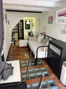 ein Wohnzimmer mit einem Bett und einem TV in der Unterkunft FRIOUL in Marseille