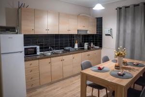 a kitchen with a table and a white refrigerator at Perikleous 5 Diamerisma KONDOULIS HOUSE in Kalabaka
