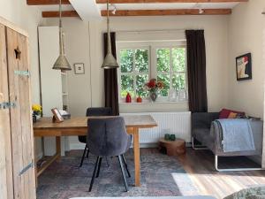 a dining room with a wooden table and chairs at B&B De Sprokkeltuin in Beuningen
