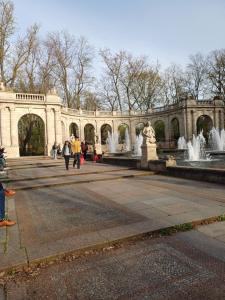 ベルリンにあるPark & City Alexの噴水のある建物の前を歩く人々