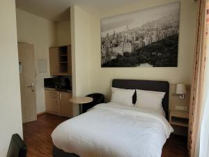 Un dormitorio con una cama blanca con una foto en la pared en Apart1hotel, en Luxemburgo