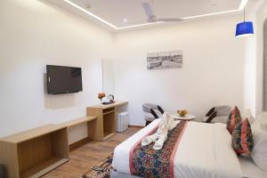 a hotel room with a bed and a flat screen tv at Hotel Luxurio by Shree Hari Hotels in Amritsar