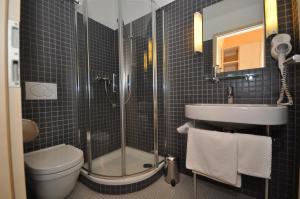 a bathroom with a shower and a toilet and a sink at Apart1hotel in Luxembourg
