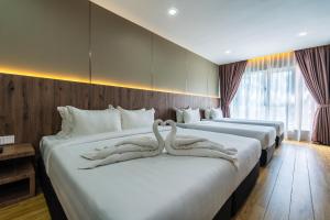 two swans are carved into two beds in a hotel room at KKIA HOTEL in Kota Kinabalu