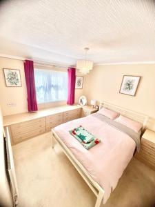 a bedroom with a bed and a window with purple curtains at Lovely spacious lodge on Trimingham house caravan park, near Cromer and Mundesley in Trimingham