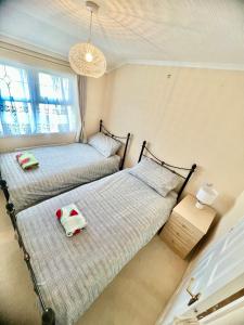 two beds sitting next to each other in a bedroom at Lovely spacious lodge on Trimingham house caravan park, near Cromer and Mundesley in Trimingham