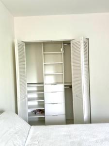 邁阿密的住宿－best life，一间设有白色门的衣柜和一张位于客房内的床