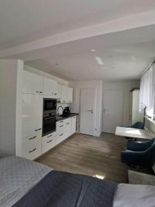 una camera con letto e una cucina con armadietti bianchi di Apartment bei der Palme mit Sauna Möglichkeit a Dusseldorf