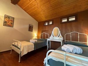 two beds in a room with a mirror at Villa del Monte di Cocco in Massarosa