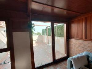 Zimmer mit einer Glasschiebetür und einer Terrasse in der Unterkunft Adosado proximo a la playa y muy espacioso, estancia semanal 15 por ciento menos y mensual 40 por ciento menos in San Fernando