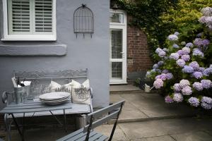 una mesa frente a una casa con flores púrpuras en Maison 5, en Harrogate 16 fotos más