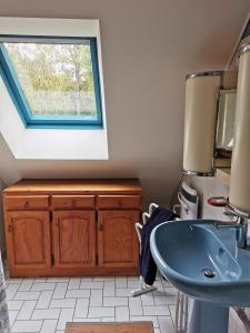 ein Bad mit einem Waschbecken und einem Fenster in der Unterkunft Chambres à la campagne chez l'habitant in Boissy-sans-Avoir
